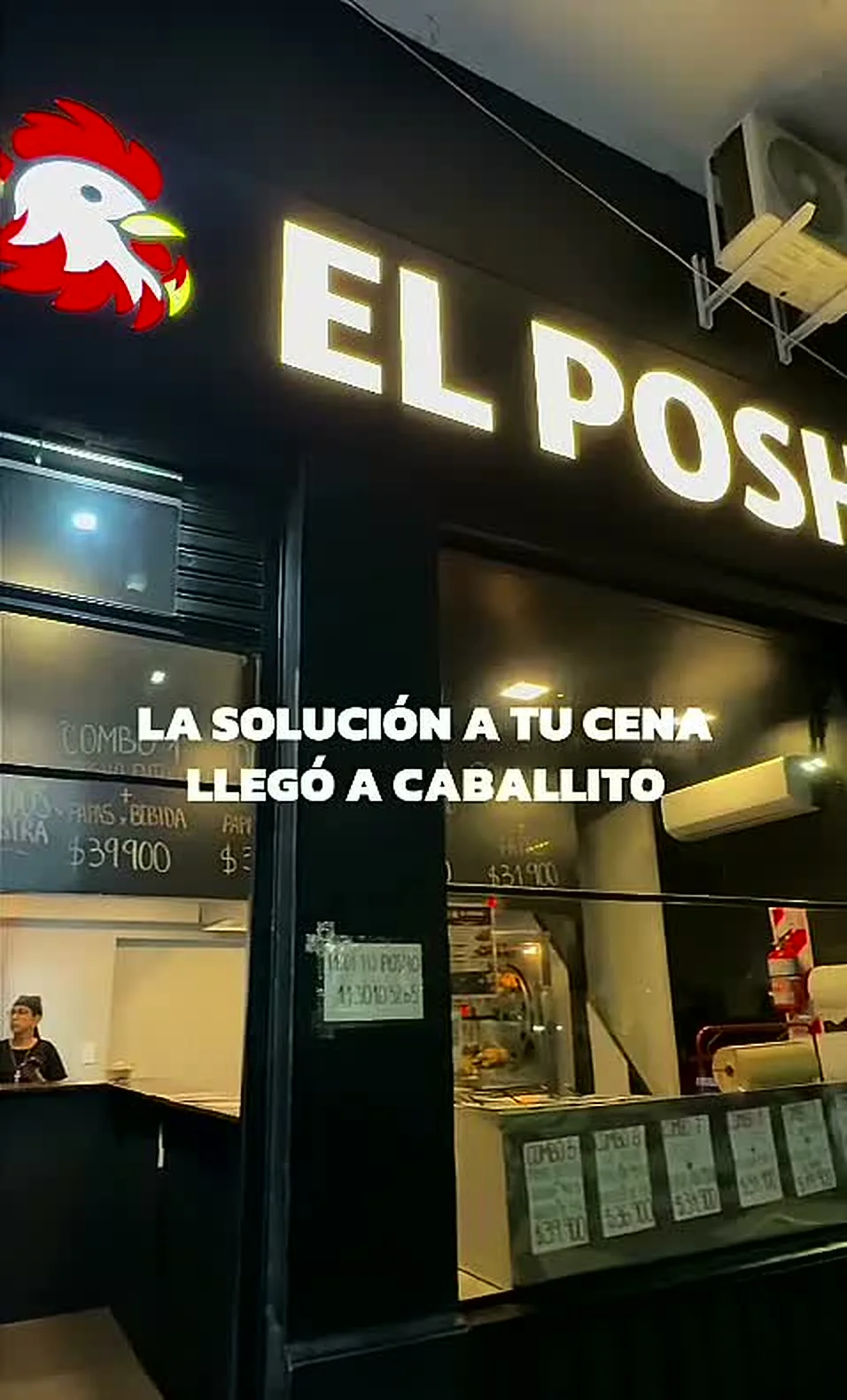 Frente del local de El Posho de noche, con el cartel iluminado